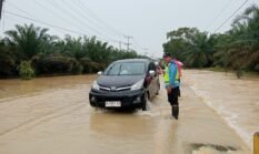 Respons Cepat Laporan Call Center 110, Polsek Padang Tualang Atur Lalu Lintas di Jalan Sumur Bor yang Tergenang Air